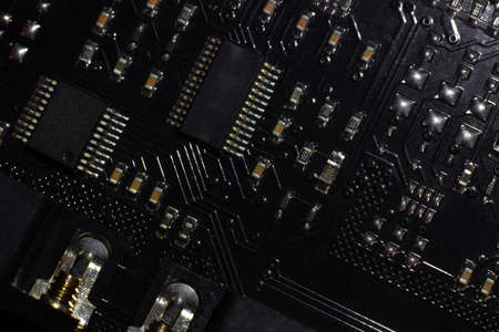 Black motherboard (PCB) digital chip. Technical science background. Integrated communication processor. Information and engineering component. Programming and technologyの写真素材