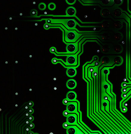 Close-up of a green printed circuit board (PCB) with stripes of conductors between a transistor and an electronic equipment processor.の写真素材