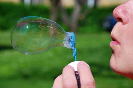 Woman blow into the soap bubble.の写真素材
