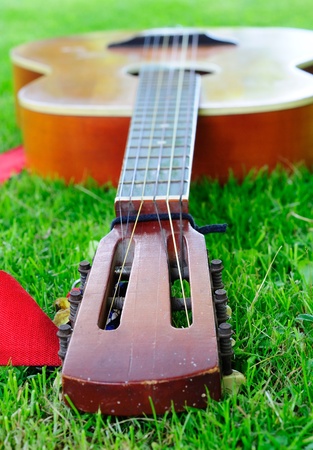 Closeup of old guitar laying on the grass.の写真素材