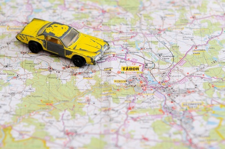 Old miniature model of retro yellow car placed on map.の写真素材