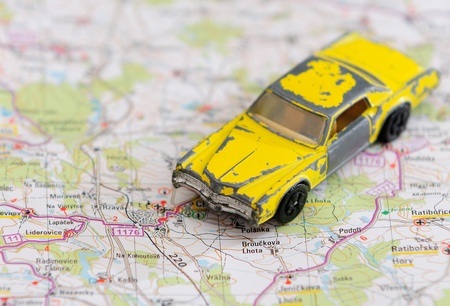 Old miniature model of retro yellow car placed on map.の写真素材