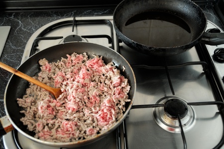 Old pan with minced pork meat on the stove の写真素材