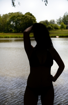 Silhouette of young girl near the pond の写真素材