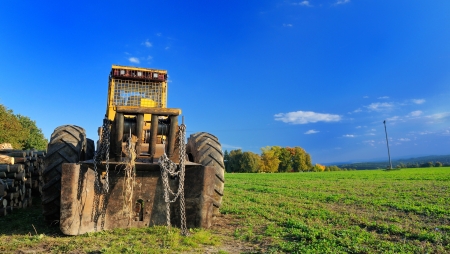 Old yellow digger parked on the field の写真素材