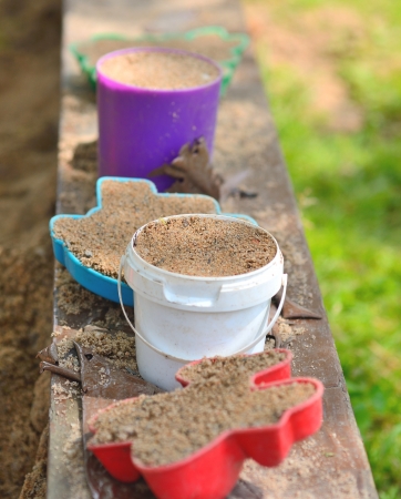 Plastic toys balanced on the border of sandpit の写真素材