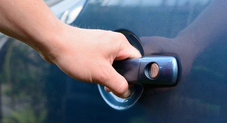 Mans hand holding the handle and opening blue car door  の写真素材