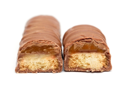 Two chocolate bars with caramel and cookie on a white background.  Front view on a chocolate bars.の写真素材