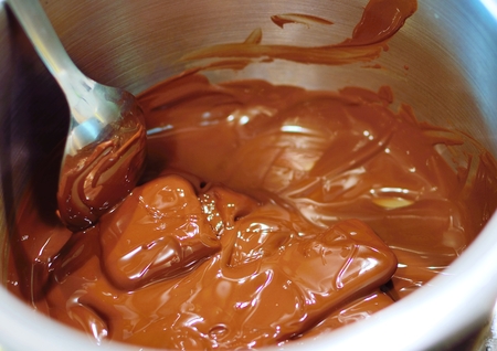 Warming of melted chocolate in bowl with spoon.の写真素材
