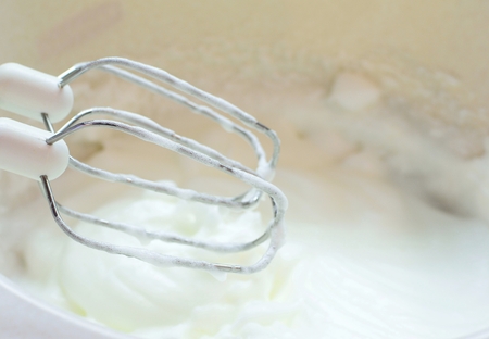 Whisk with egg white mixing into snow.の写真素材