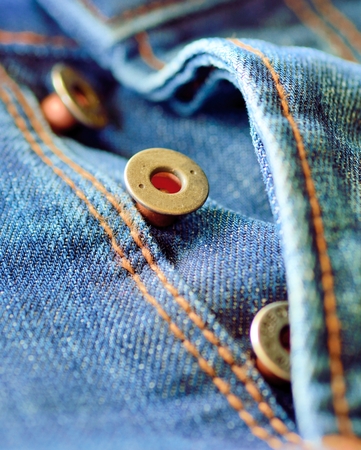 Front piece of the blue jeans. Open buttons fly. Button macro. Jeans button.