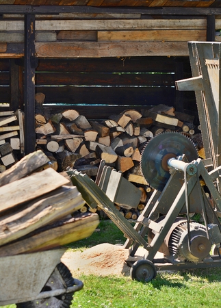 Circular saw with wood logs and log store in garden. Woodworking in garden.の写真素材