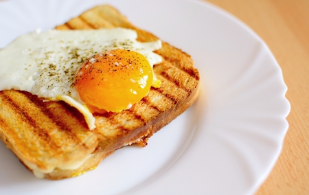 Ham and cheese toast with fried egg on top.の写真素材