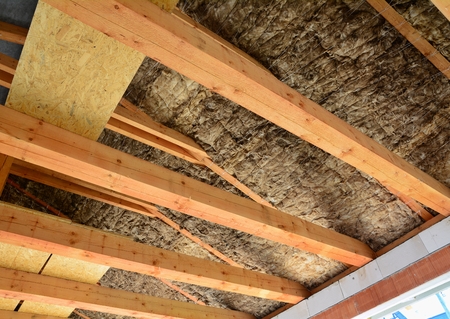Roof and attic insulation over wooden beams in a new house.