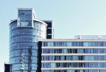 A front view of modern office glass building exterior against the blue sky.の写真素材