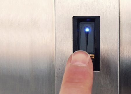The finger is touching the fingerprint biometric sensor for unlocking door or lock.の写真素材