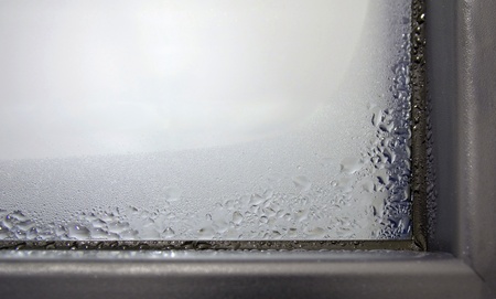 Closeup of the winter condensation on the inside of a window, insulation failure. A window glass covered with condensation drops.の写真素材