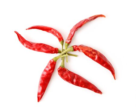 Top view of dried red hot chilli peppers arranged in a star shape on white background.の写真素材