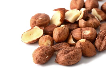 Heap of peeled scattered hazelnuts over white background.の写真素材