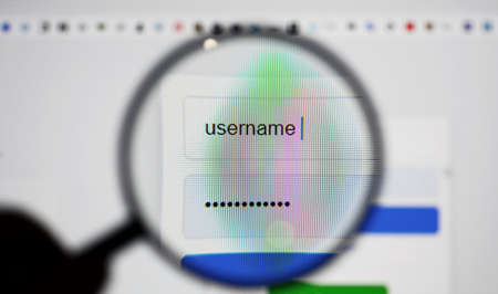 View through a magnifying glass on login page screen with username and password box in internet...