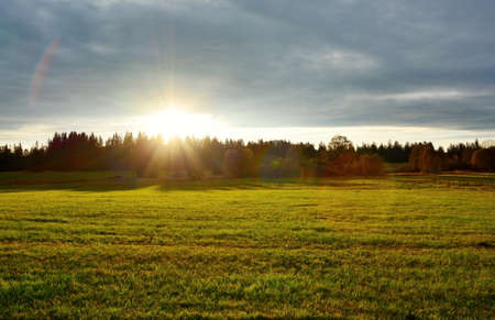Beautiful sunset over meadow and forest near Kvilda village in Sumava National Park landscape.の写真素材
