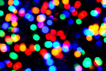 Blurred glittering christmas LED multi color lights, circle color bokeh on dark background.の写真素材