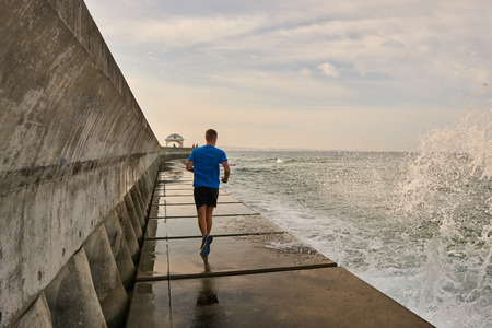 Man running on seawallの写真素材