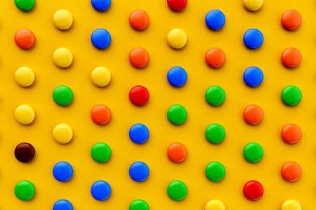 Colorful candy pattern on a yellow background viewed from above. Sweet bonbons isolated on a yellow...