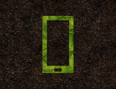 Smart Phone shape of green leaves on Soil background ecology conceptの写真素材