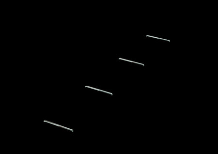 A Line Of Metallic Staple Pins Are Embedded In Black Background 3D Illustrationの写真素材