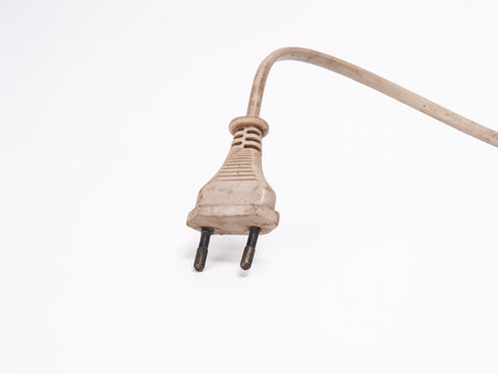 Old dirty white power plug and cable isolated on a clean white background.