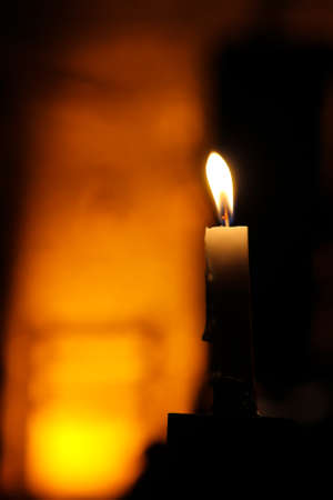 Burning candle on dark background, shallow depth of field. Selective focus.の写真素材