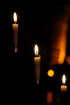 Burning candles on dark background, closeup. Space for textの写真素材