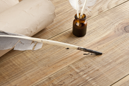 Old paper and feather with ink on a wooden tableの写真素材