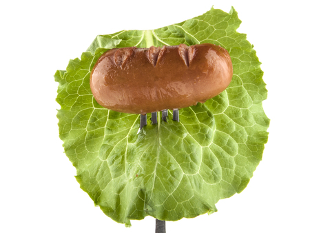 fried sausage  and salad on a metal forkの写真素材