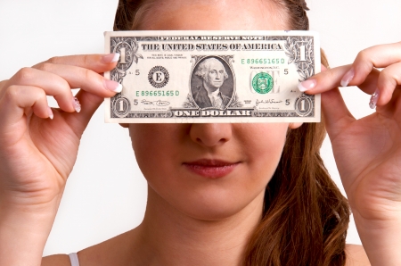 Beautiful teen girl shows one dollar in front of her eyes 