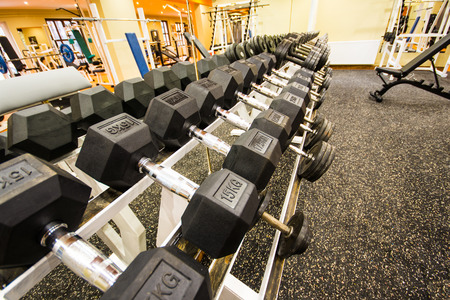 View of rows of dumbbells on a rack in a gymの写真素材
