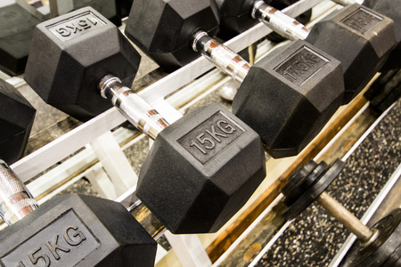 View of rows of dumbbells on a rack in a gymの写真素材