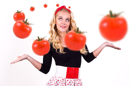 Woman with flying tomatoes. Isolated background.の写真素材