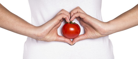 smiling woman with organic food showing heart shape with handsの写真素材