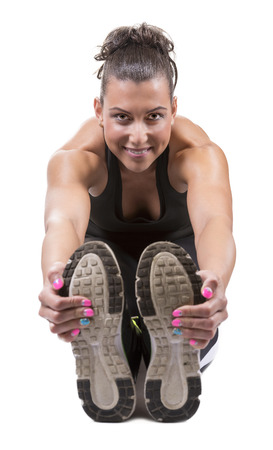 Fitness girl streching in a studio. Isolated on white.の写真素材