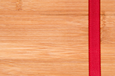 Red ribbon on woodの写真素材