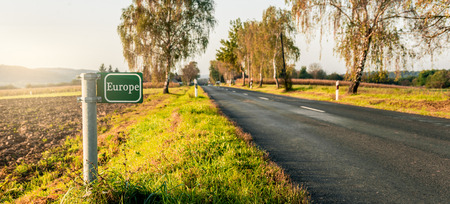 green signboard at the roadside in an autumn landscape. Europe text.の写真素材