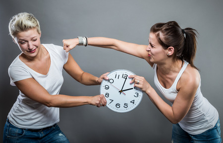Portrait of beautiful smiling women holding a big clock in her hands.の写真素材
