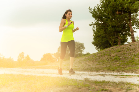 Woman Running In Countryside at beautiful sunset.の写真素材