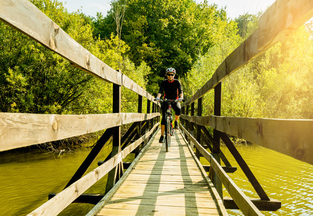 Young biker woman riding a bike in a bridge.の写真素材