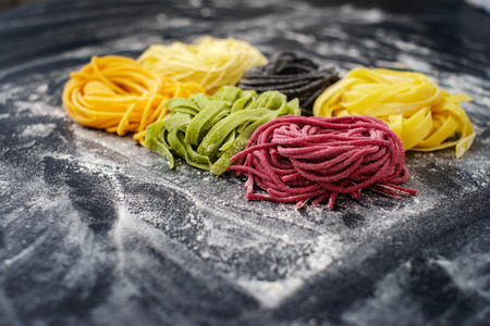 Colored raw pasta on black backgroundの写真素材