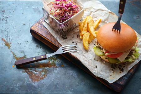 cheeseburger home cooking on rusty steel background close fried potatoes and saladの写真素材
