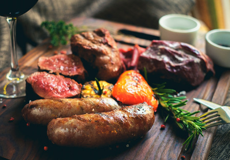 the mix meat grilled on the Board with a red wine, salt, pepper, garlic and herbsの写真素材