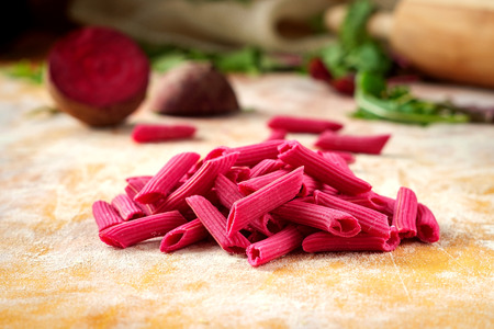 Hand made beetroot pasta on a wooden table. Raw purple penneの写真素材